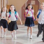 Elevi, copii cu ghiozdanele in spate la scoala / Foto: Freepik.com
